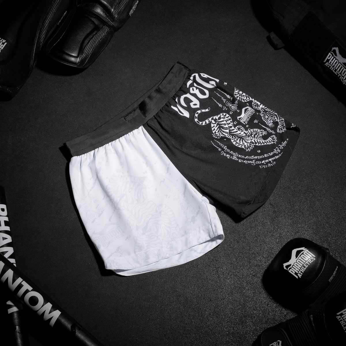 Diese Fightshorts aus atmungsaktivem, reißfestem Material sorgen für Komfort und Langlebigkeit in Muay Thai und Kickboxen. Das dezente Schwarz-Weiß-Design verleiht einen klassischen Look, ideal für anspruchsvolle Kampfsportler.