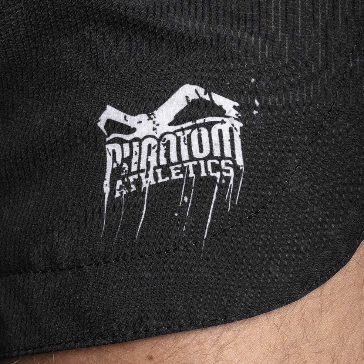 Detailaufnahme des Ripstop-Gewebes an den Fusion-R Pumpkill Fightshorts. Die Fightshorts sind mit strapazierfähigem Ripstop-Gewebe ausgestattet, das gegen Abrieb schützt und in jeder Kampfsituation zuverlässige Stabilität bietet.