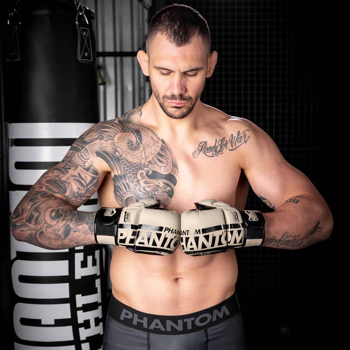 UFC Star Aleks Rakic mit den Phantom MMA Handschuhen in Sand und der Phantom APEX Fightshorts im Gym beim Boxsack Training