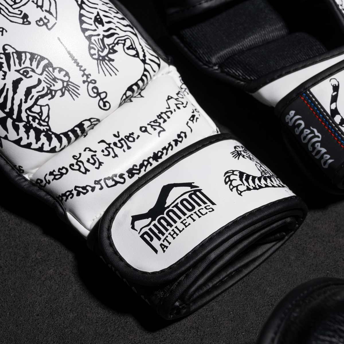 Phantom Muay Thai Handschuhe für Thaiboxen und MMA Sparring, Wettkampf und Training. Im traditionellen Sak Yant Design und der Farbe Weiß.