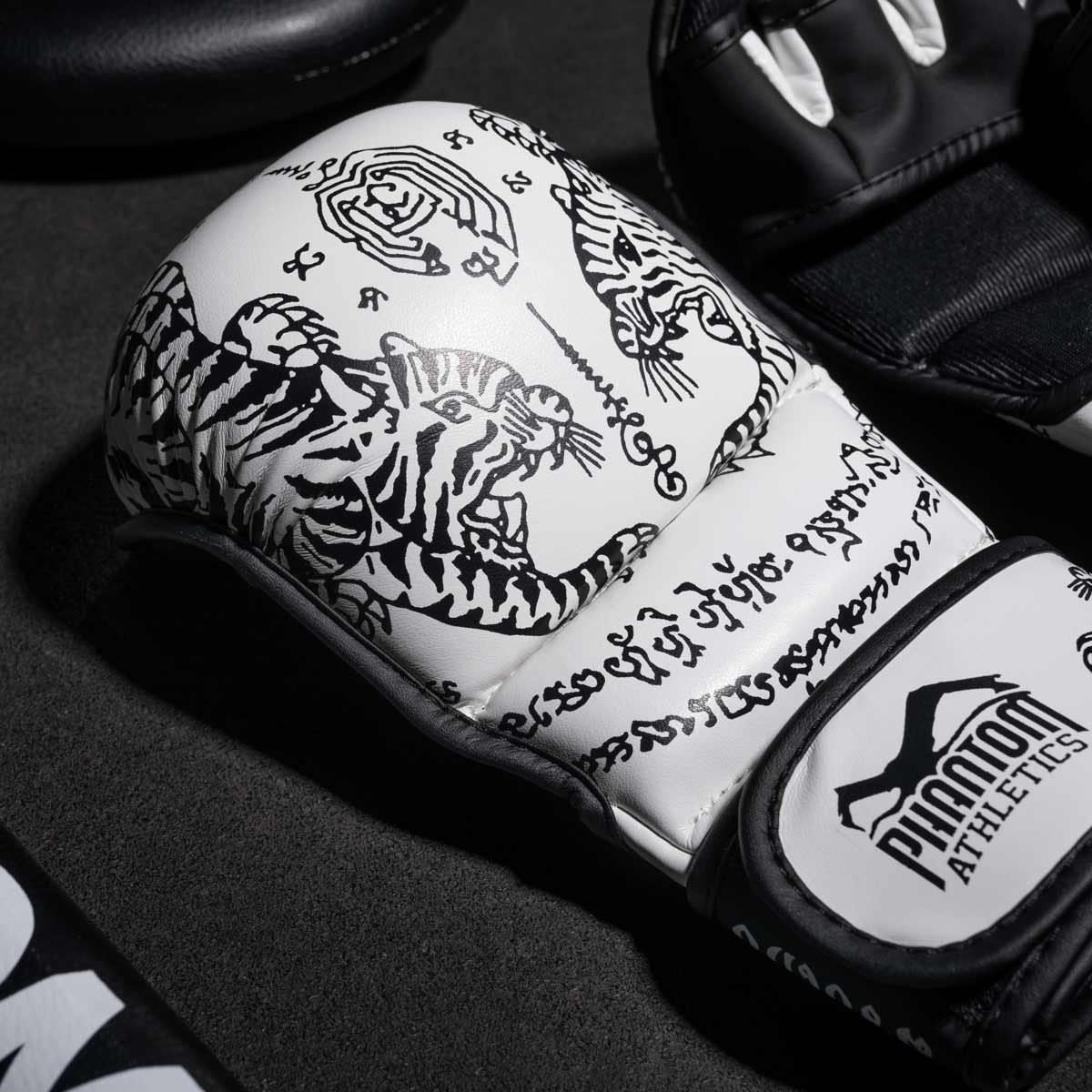 Phantom Muay Thai Handschuhe für Thaiboxen und MMA Sparring, Wettkampf und Training. Im traditionellen Sak Yant Design und der Farbe Weiß.