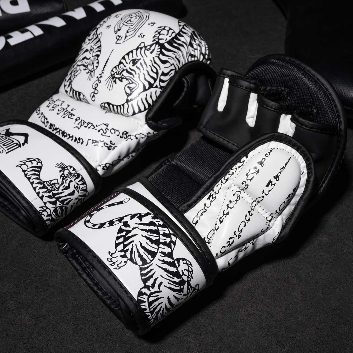 Phantom Muay Thai Handschuhe für Thaiboxen und MMA Sparring, Wettkampf und Training. Im traditionellen Sak Yant Design und der Farbe Weiß.