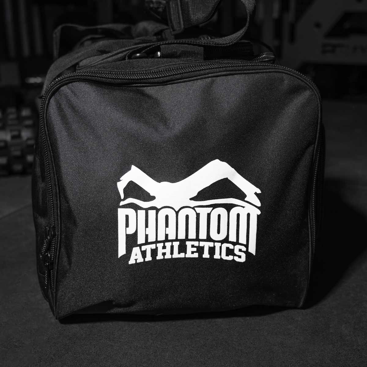 Die TEAM Muay Thai Sporttasche von Phantom Athletics bietet nicht nur Platz für Handschuhe, Schienbeinschoner und Bekleidung, sondern auch für Zubehör wie Bandagen und Wasserflaschen. Die verstärkten Tragegriffe und der abnehmbare Schultergurt machen den Transport der Kampfsport-Ausrüstung besonders bequem.