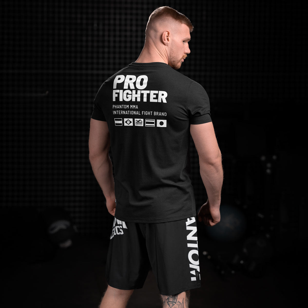 Mit seinem sportlichen Look und atmungsaktiven Material ist das Pro Fighter T-Shirt von Phantom Athletics die ideale Wahl für Kampfsport und Fitness. Der klassische Schnitt kombiniert Stil und Funktionalität, perfekt für sowohl intensives Training als auch entspannte Tage.