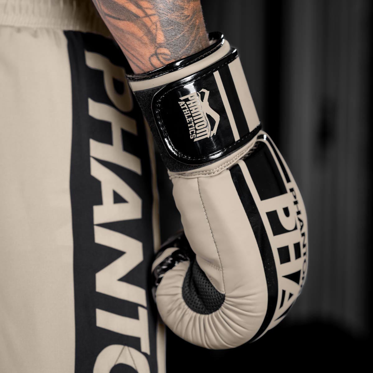 Die Boxhandschuhe Apex Sand von Phantom Athletics kombinieren Komfort mit Funktionalität und eignen sich perfekt für anspruchsvolle Trainingseinheiten. Der breite Klettverschluss hält die Handschuhe stabil und schützt das Handgelenk vor Verletzungen. Diese Handschuhe sind ideal für intensives Training im Boxen und Muay Thai.