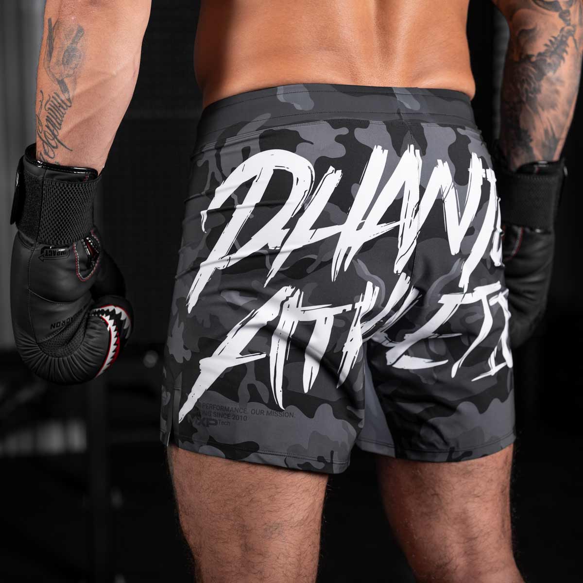 Die Phantom FLEX Fightshorts zählen zu den besten Fightshorts am Markt. Ultraleicht, mega flexibel und reißfest. Reduziert auf ein absolutes Minimum bietet sie dir maximale Performance in deinem Kampfsport. Egal ob BJJ, MMA, Muay Thai oder Kickboxen. Die FLEX Shorts von Phantom Athletics holen das beste aus dir raus. Hier im beliebten Urban Camo Look in schwarz/grau und großem Phantom Athletics Schriftzug auf der Rückseite.  UFC MMA Fighter Aleks Rakic beim Training.