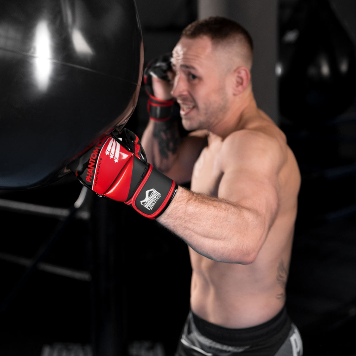 GMC und PFL Fighter Anatolij Baal schlägt einen Uppercut am Phantom Hydro Boxsack mit den neuen Phantom RAIDER MMA Sparringshandschuhen