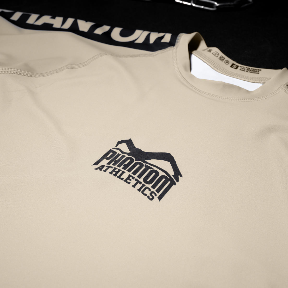 Phantom Rashguard für deinen Kampfsport. Eng anliegendes Kompressionstop für MMA, BJJ, Ringen, Muay Thai und andere Fight Sportarten. Perfekte Verarbeitung, Tragekomfort und Performance. Ideal für Training und Wettkampf. Hier im Sand farbenen Apex Design.