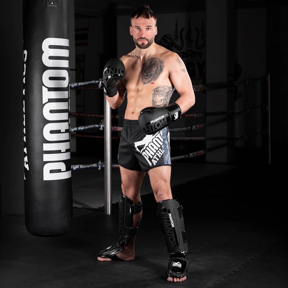 Muay Thai Profi im Gym mit den Phantom Apex Hybrid Schienbeinschützern und den Apex Boxhandschuhen