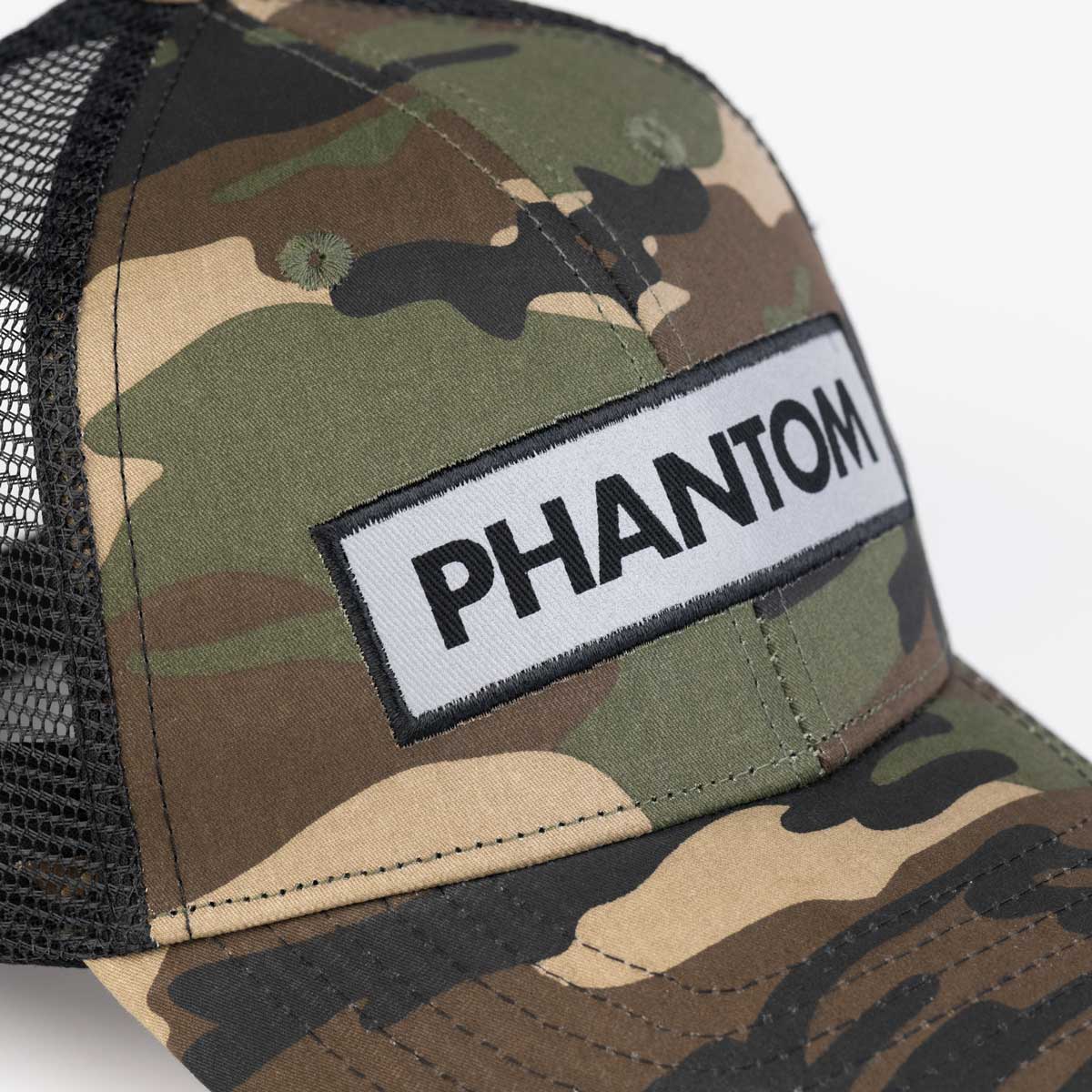 Phantom Cap für Kampfsportler im Trucker Style mit atmungsaktivem MESH Teil an der Hinterseite. Grün Camo mit gebogenem Schirm und hochwertig gesticktem Phantom Logo welches reflektiert. Ideal für dein Outdoor Workout und perfekt für alle MMA Kämpfer, Boxer, BJJ Kämpfer, Thaiboxer oder Kickboxer.